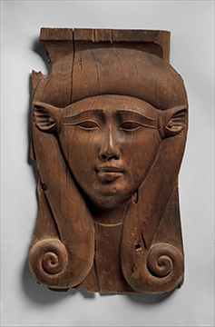 A wooden carving of a female face