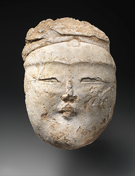 A stone sculpture of a female face